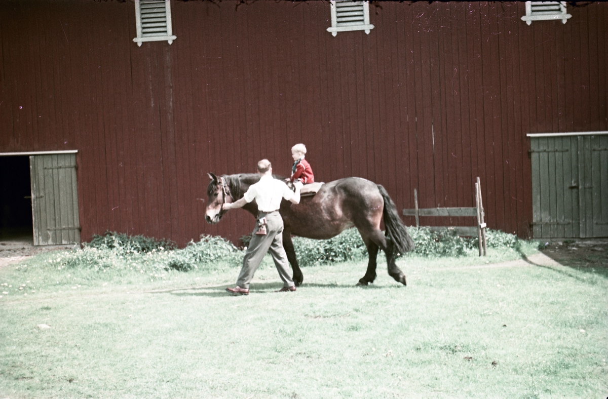 Geir Huset på hesterygg mens far Arnulf passer på. Stedet er gården Huset i Askim juni 1957.