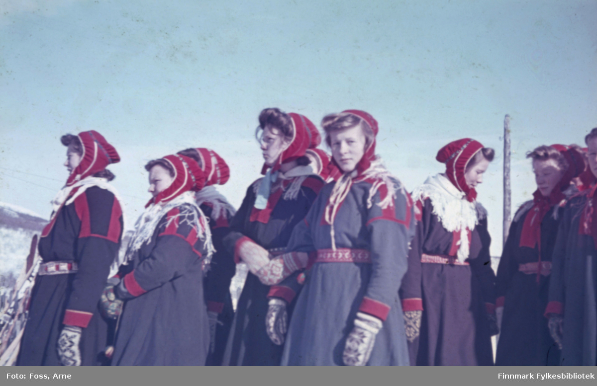 Samiske kvinner og jenter venter på brudeparet utenfor Polmak kirke på 2. påskedag i 1947. Antakelig fra venstre Kirsten Losoa, Magna Länsman, Charlotte Aslaksen, Frøydis Aslaksen, Kristine Nilsen og den siste er ukjent.