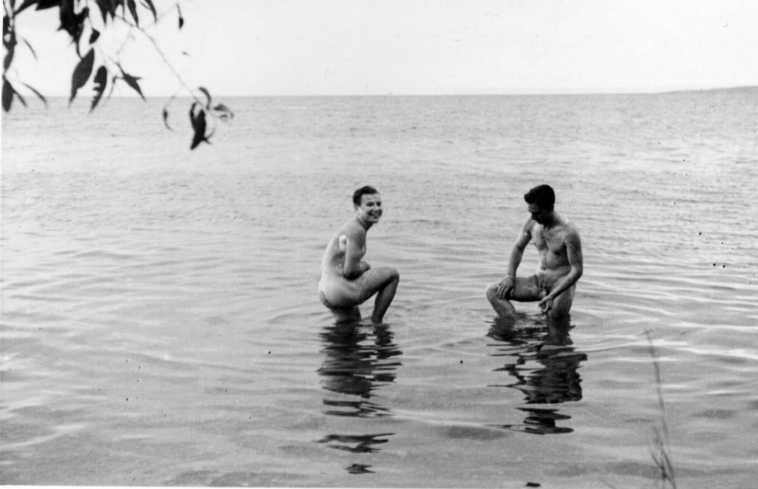 Två nakna män som tvättar sig i en sjö, troligen Vättern.
