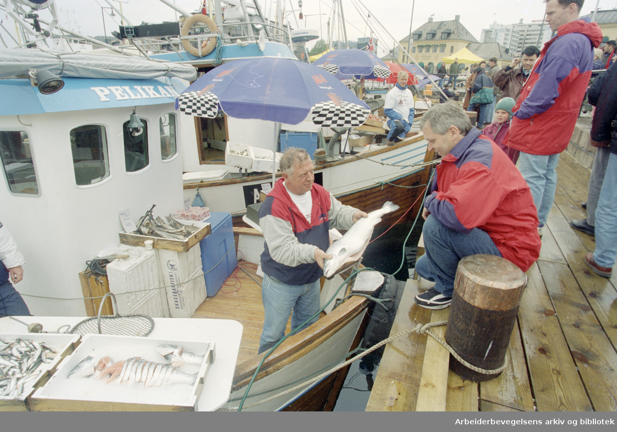 Oslo: Havna. Diverse stemningsbilder. Fiskeskipper Jan Johannesen (t.v.) ombord på "Pelikan" selger fisk til Harald Kristoffersen. 17. mai 1996