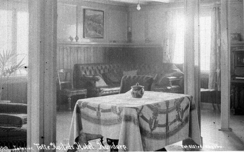 Sør-Fron. Hundorp. Nordre Lia. Tofte sanatorium. Interiør med bord og duk, sofa og stoler, bilde, gardiner. Søyler.