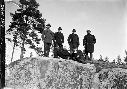 Sex män i skogen på berghäll, Riddarhyttan.