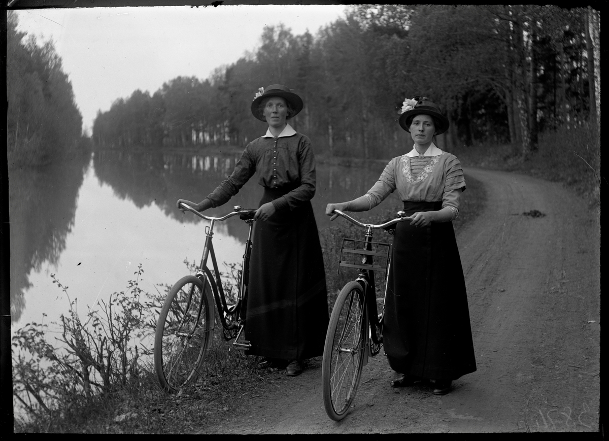 Cyklande kvinnor på kanalbanken
