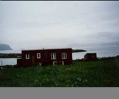 Et bygg på Melkøya med utsikt over Sørøysundet. På venstre side vises det en del av Håja i bakgrunnen.