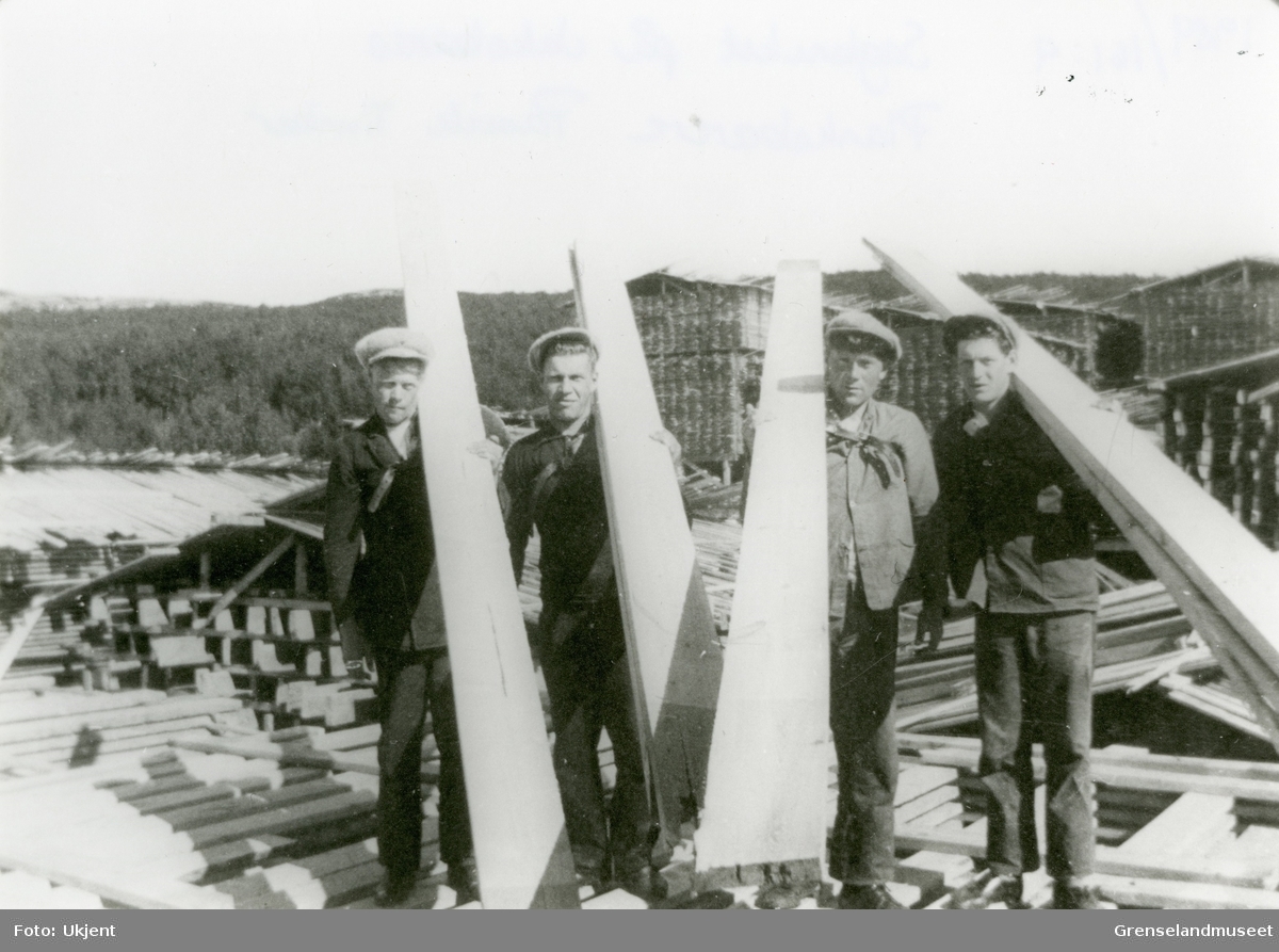 Motiv fra sagbruket på Jakobsnes før 1940. Plankebærere, materialstabler i bakgrunnen.