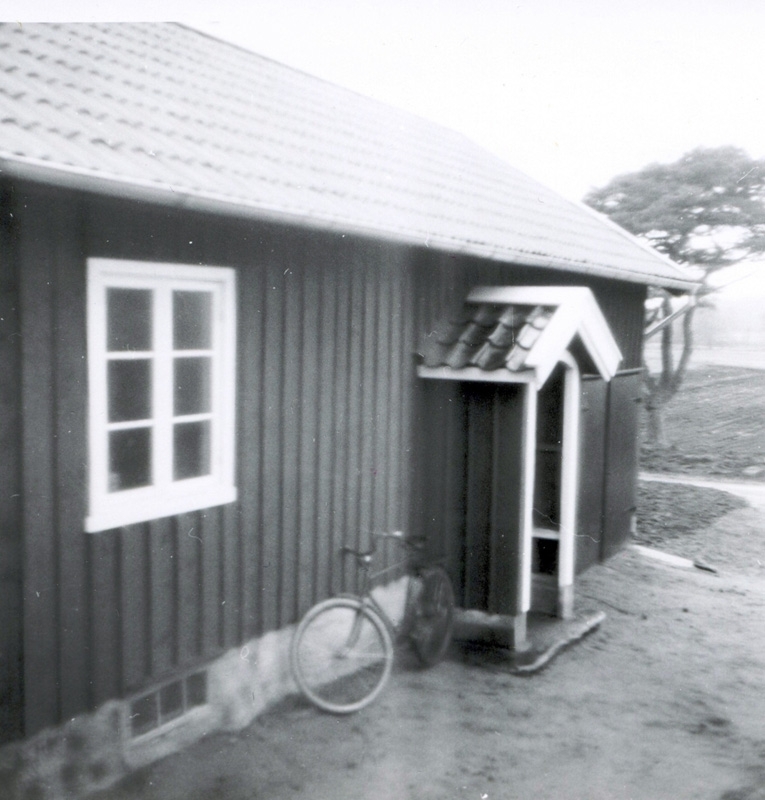 Magasinsbyggnad och snickarbod vid "Mattssons" Tulebo Nordgård 1960-tal. En cykel står lutad mot byggnaden.