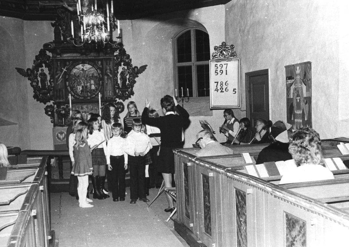 En barnkör sjunger under ledning av organist Eva Karlsson i Kållereds kyrka (Svenska kyrkan) innan 1976.