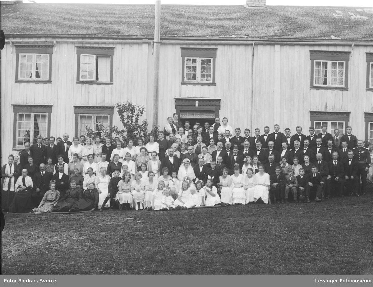 Gruppebilde foran trønderlåna på Munkeby vestre. Bryllupet til Aslaug Munkeby og Hartvik Eliasson 1. juli 1920.