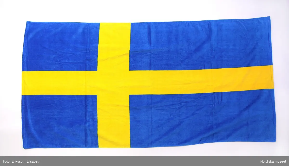 Badlakan av bomullsfrotté. Dekormotiv är svenska flaggan.