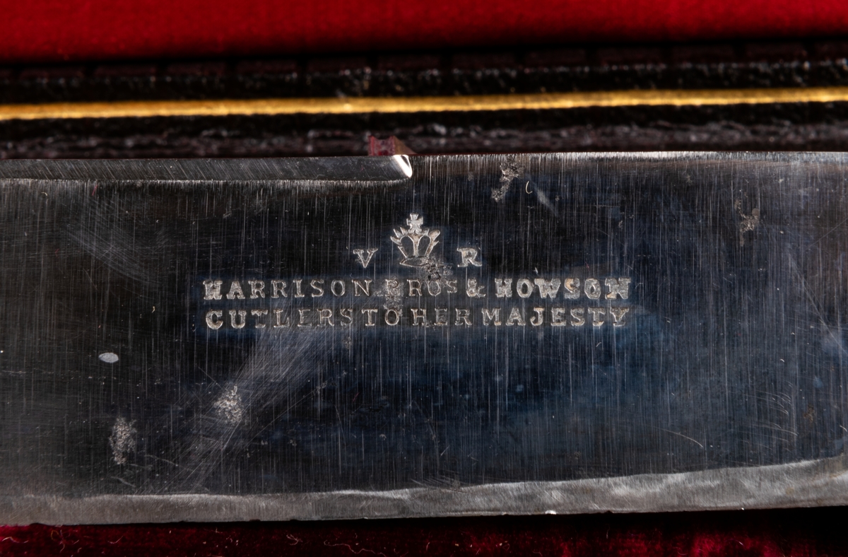 Stekgarnityr i svart fodral med initialerna P.E. i guld. Skaft med snirkligt monogram. Stämpel "V R".

Harrison Bros & Hovsson Cutlers to her Majesty.