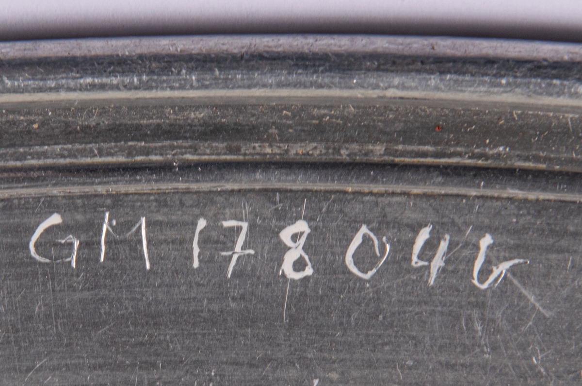 Uppläggningsfat av aluminium. Ovala med slät dekorskåra i brättet.
b: Stämplar (krona) Skultuna 1607 38cm. Mått: 38 x 24cm.