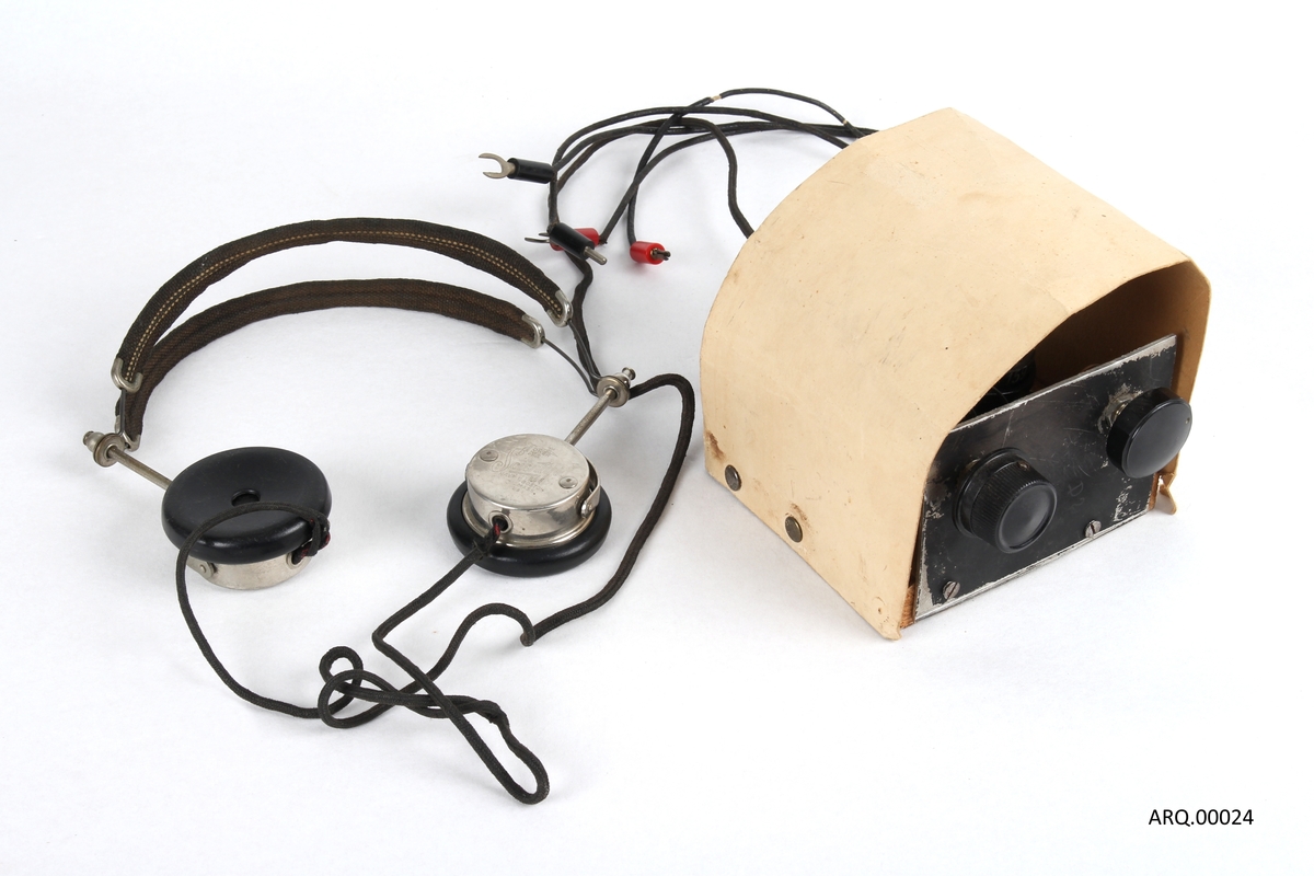 Hjemmelaget radio med tilhørende hodetelefoner. Laget i Haugesund og var brukt til radiolytting under andreverdenskrig