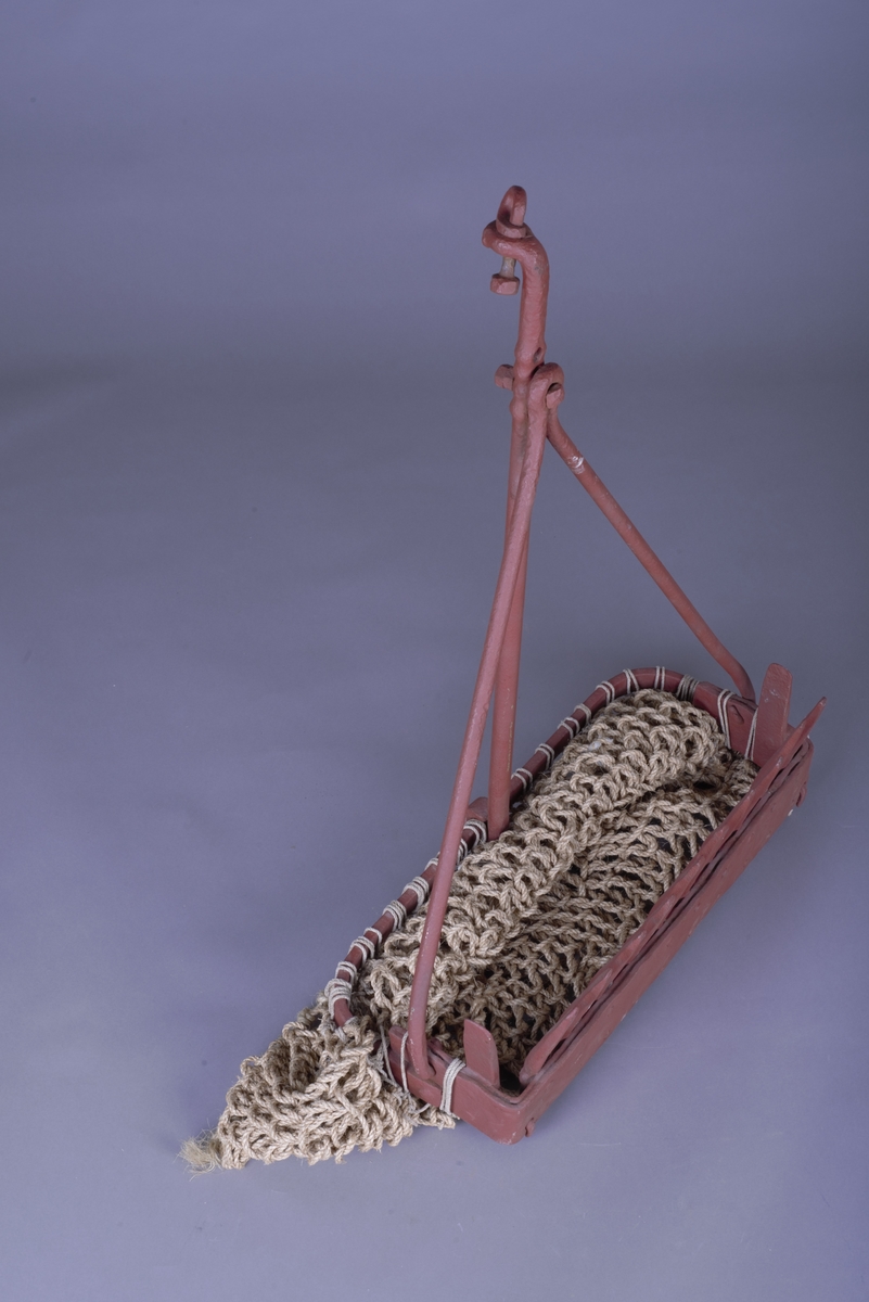 Skjell eller skalldyrskrape, laget av metall med et nett av tau. 
12 tenner på skrapens underside fungerte som ei rake som samlet sammen skjell og skalldyr langs havbunnen, som fiskeren brukte som agn.