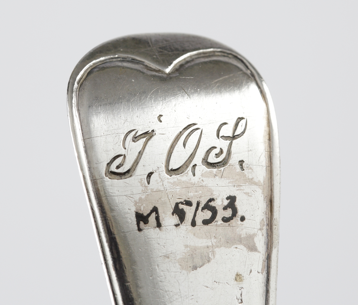 Strösked i silver.
Svensk trubbig modell. Perforerat runt skedblad med genombrutet strålformat mönster och fem runda hål. Längst ut två rader med avlånga genombrytningar. Ägarinitialer: "I.O.S." på baksidan av skaftet. Stämplar på baksidan av skaftet.