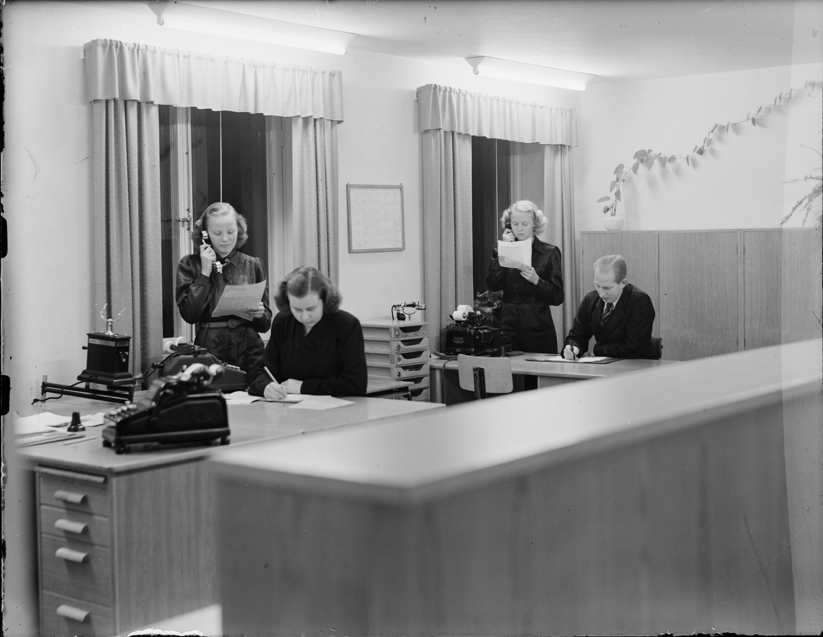 Kvinnor och man arbetar vid skrivbord, Uppland