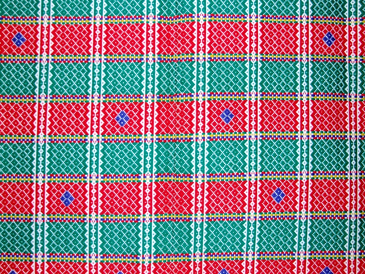 Mønster i striper. Små blå diamamtmønster rundt i kring på teppet. 