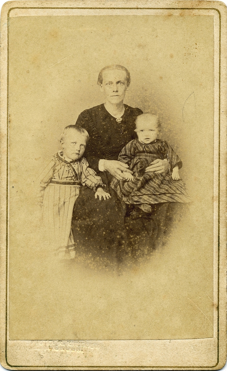 Portrettfotografi av ei kvinne med to barn.