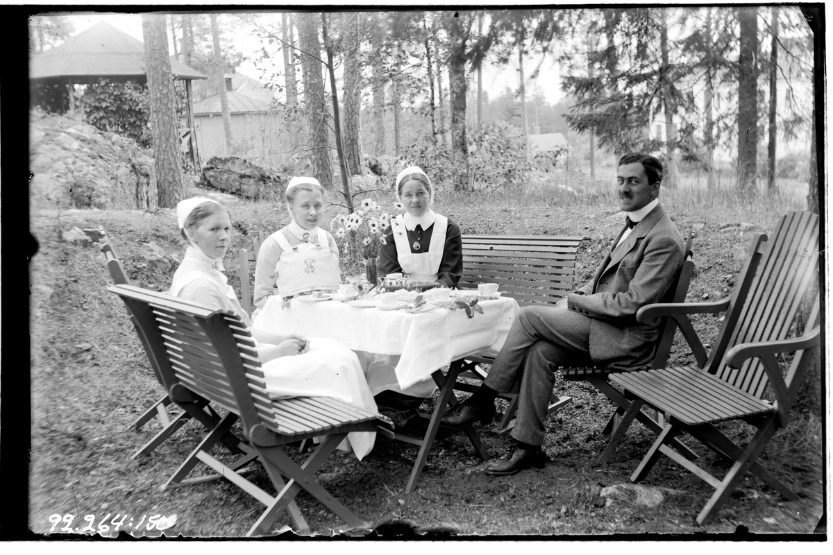 Hålahult sanatorium, exteriör, tre kvinnor i uniform och en man runt ett kaffebord i naturen, manen underläkare J.B. Sundström 1/7 1915 - 15/8 1915