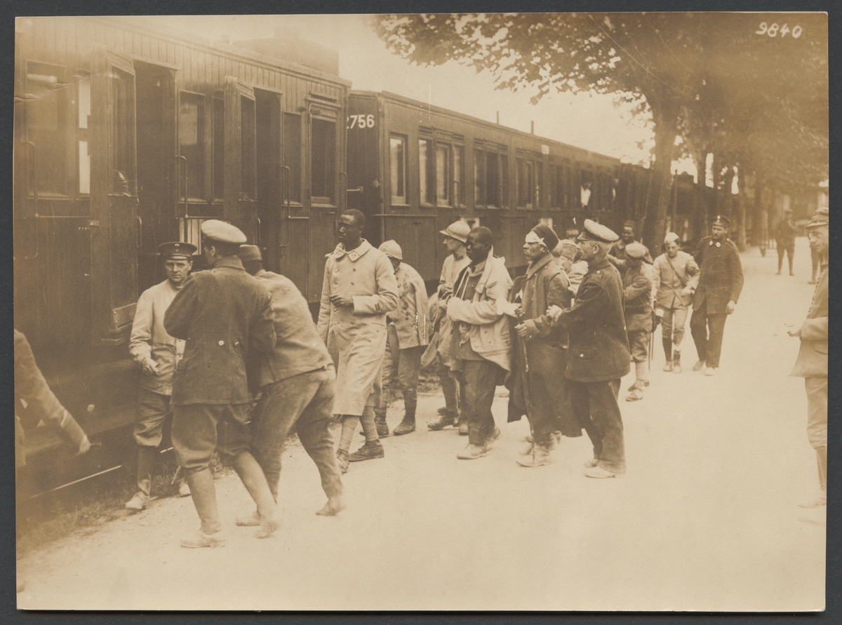 Bilden visar sårade franska krigsfångar med olika härkomster som föras fram till ett lasarettståg.