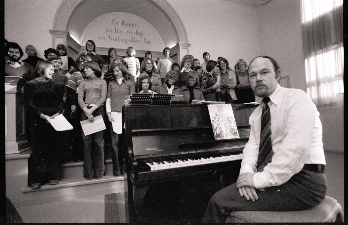 Mann med piano og sangkor i Baptistkirka.