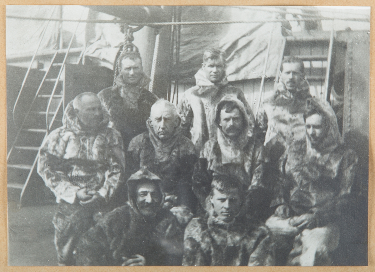 Gruppebilde av Roald Amundsen og (antall?) menn i skinnklær, på båtdekk, Maudekspedisjonen