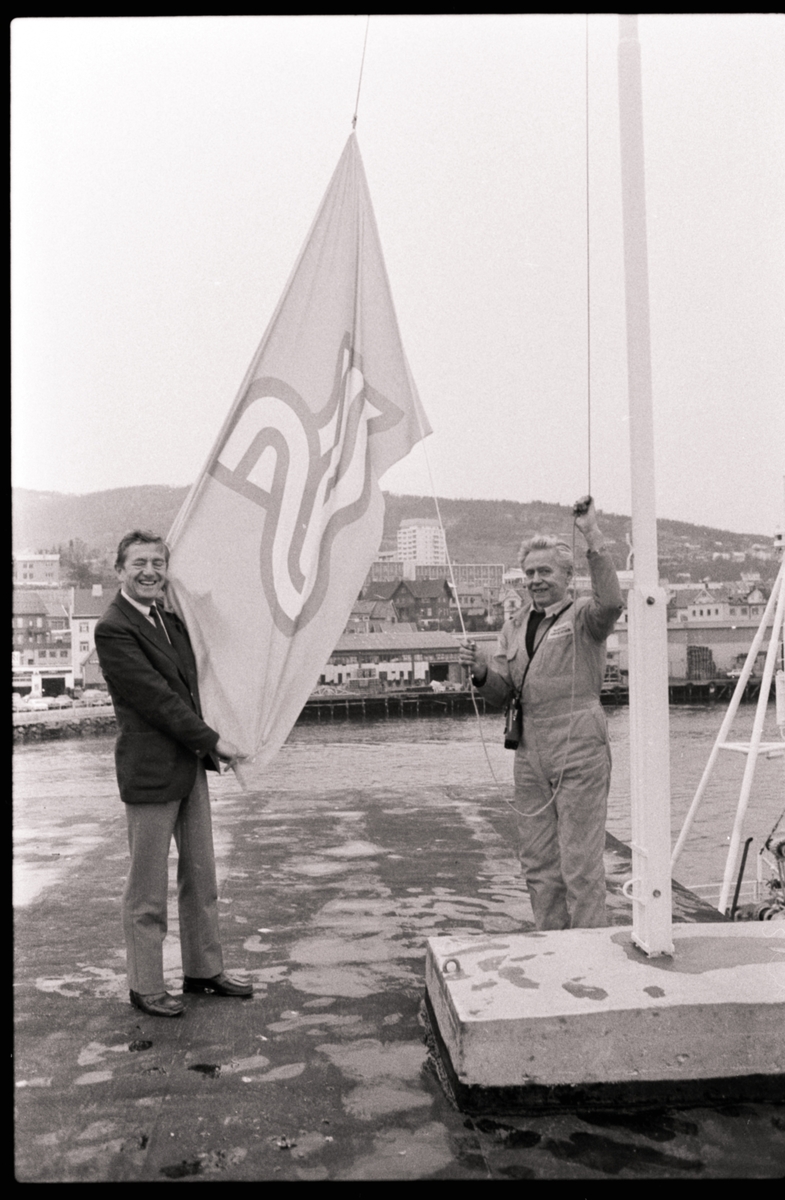 Havnesjef Ragnar Tønder og havnebetjent Eilert Jensen med flagg på dampskipskaia.