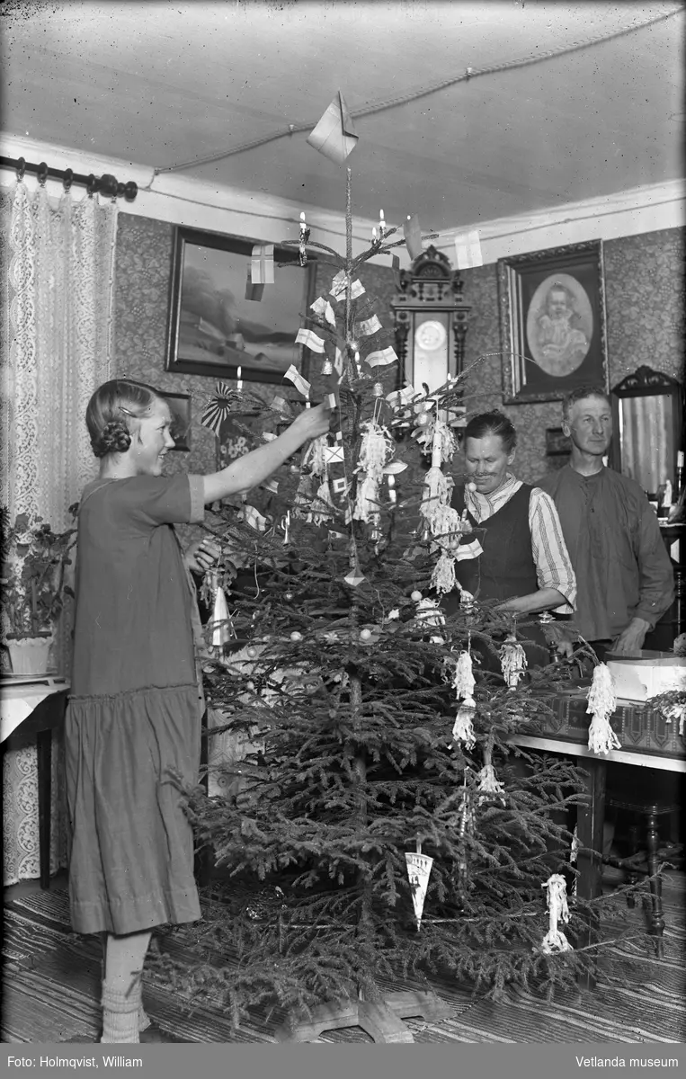 Familj klär julgranen. Fotografi från området Österstand i Vetlanda.