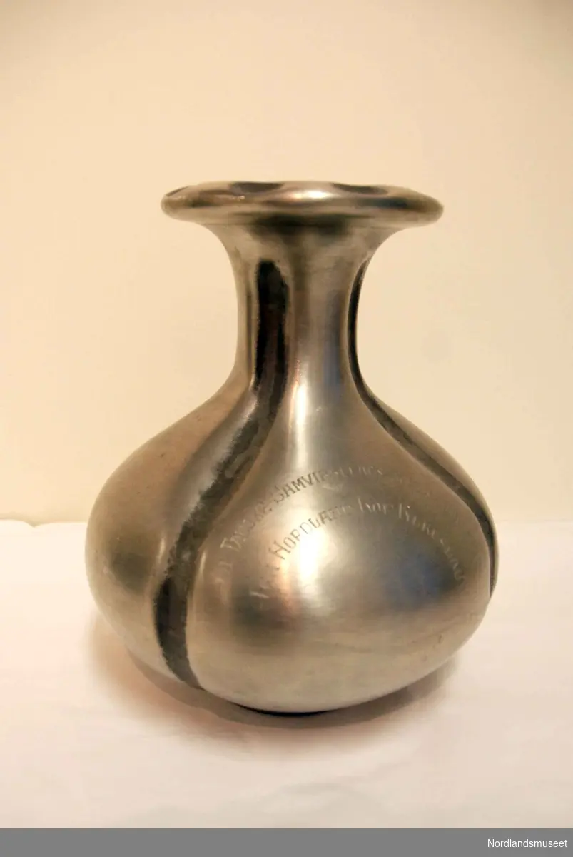 Vase i metall med inskripsjonen: TIL FAUSKE SAMVIRKELAGS 50 ÅRS JUBILEUM FRA NORDLAND KOP. FYLKESLAG