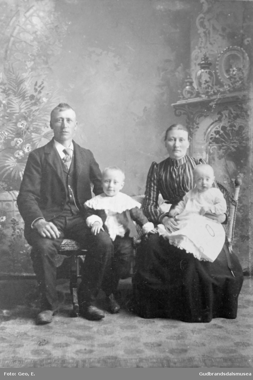 Portrettbilde, familie, mann og kone med to barn, ett barn på fanget til kvinnen, atelierfotografi av Ensrud.