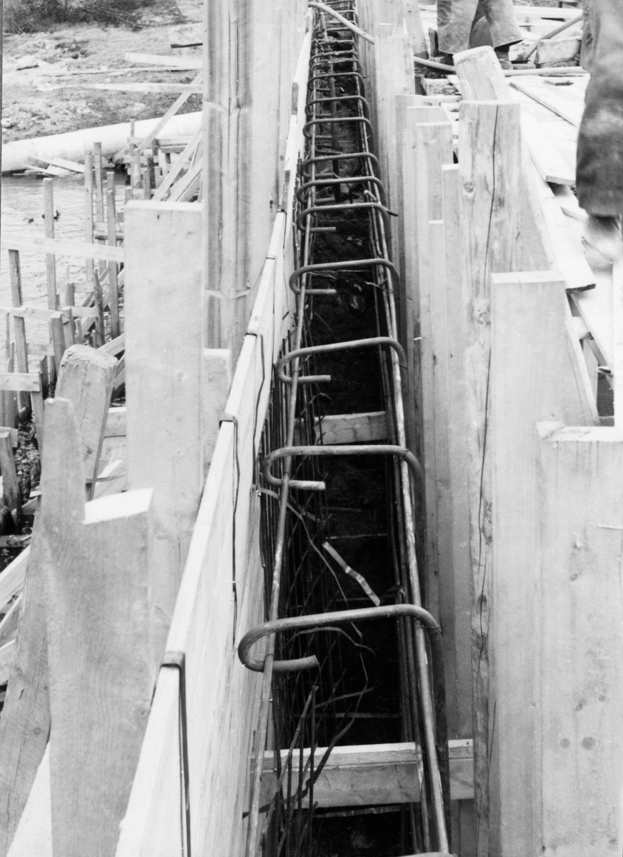 Forskaling til kaimur ved Glomma fellesfløtingsforenings anlegg på Furuholmen i Varteig i Østfold.  Her ble det i 1953-54 bygd et nytt administrasjonssenter for fløtinga i den nedre delen av vassdraget, og noe av det første som ble bygd var nettopp kaianlegget.  Dette fotografiet viser forskalingas overdel, fotografert parallelt med det som skulle bli murens lengderetning.  Bildet viser også hvordan forskalinga var utført med 2” X 4” stendere og innvendig bordkledning, og hvordan armeringsstålet var bindet her oppunder det som skulle bli murkrona. 
