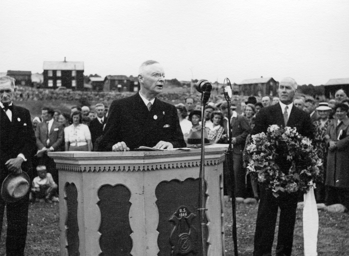 Direktør Lange taler i forbindelse med bekransning av bergmannsminnesmerket på øvre kirkegård ved 300-årsjubileet for Røros Kobberverk i 1946. Styremedlem Bjarne Reitan holder kransen