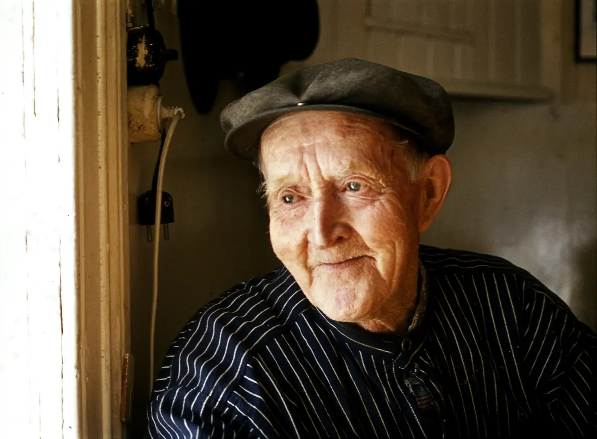 Berhard Knippa  fotografert av Dagfinn Grønoset mens han ser ut gjennom døra.