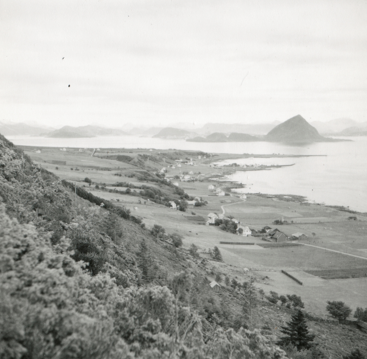Oversiktsbilde fra sør-østsiden av Godøy der Gøygarden ligger. Fjellene med Sukkertoppen i bakgrunnen.