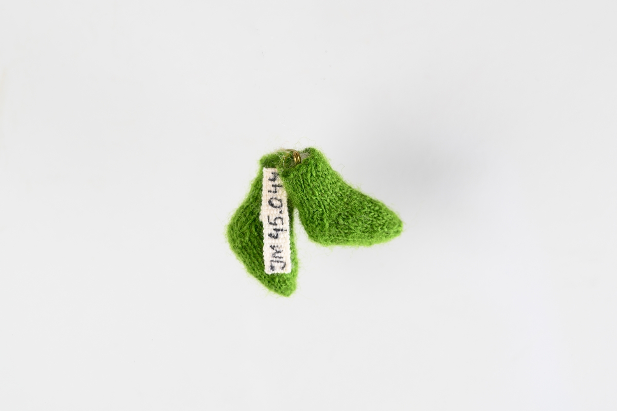 Miniatyrstrumpor, ett par. Gröna stickade strumpor fyllda med vadd.