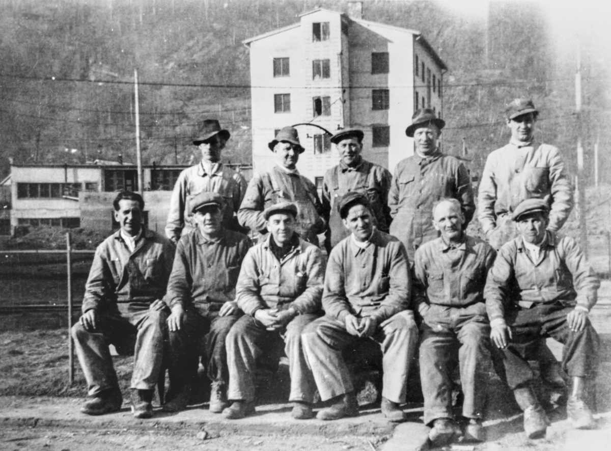 Arbeidslag på Smelteverket, Odda brannstasjon i bakgrunnen (bygd 1950-52)