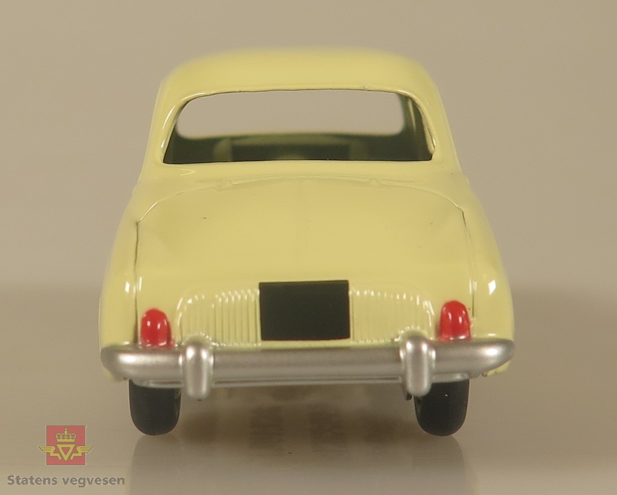 En liten gul modellbil, med kromfarget metallribbe på baksiden av døren.