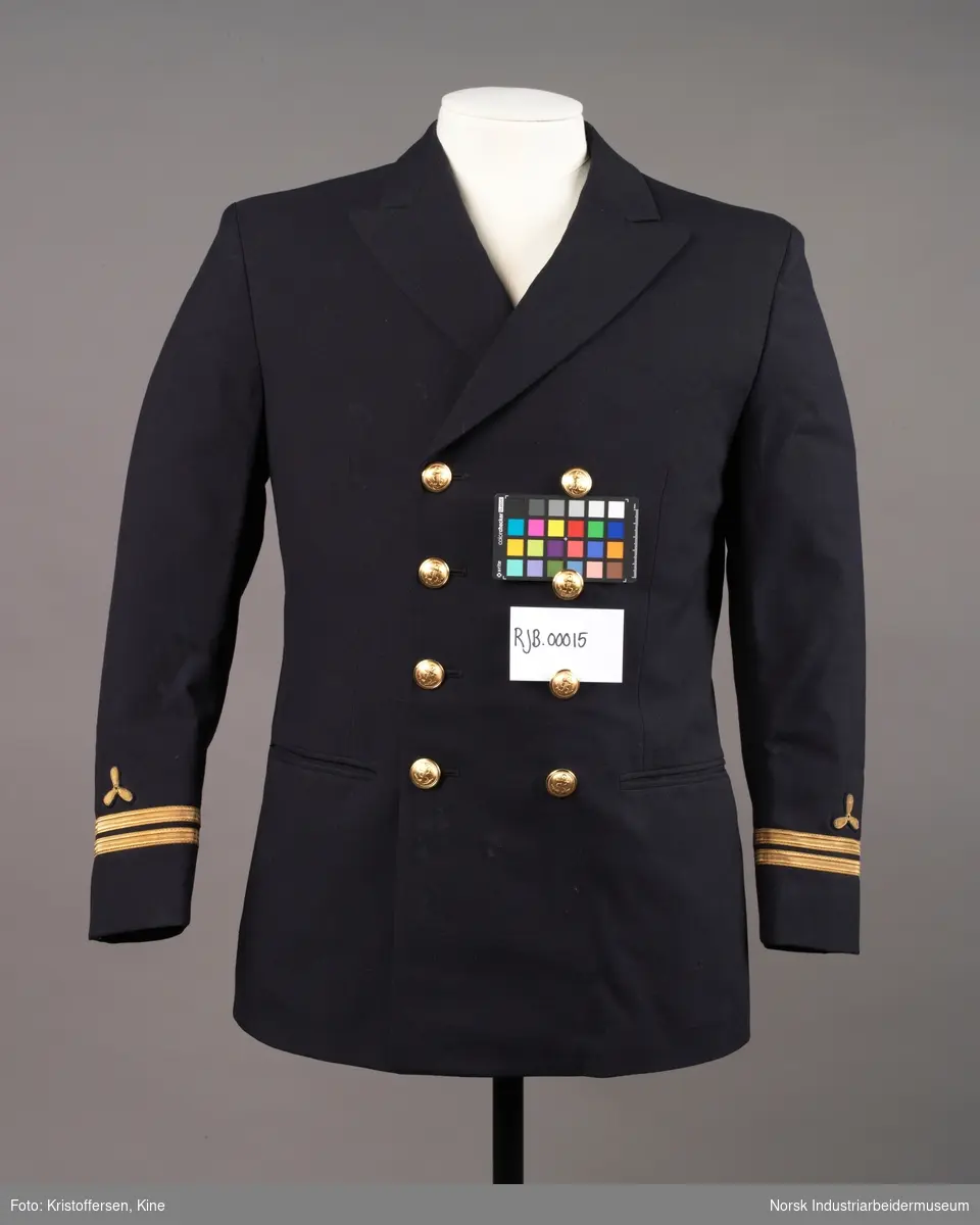 Uniformsjakke til maskinist med åtte gullknapper med ankerlogo. To striper og propellogo i gull på hvert erme.