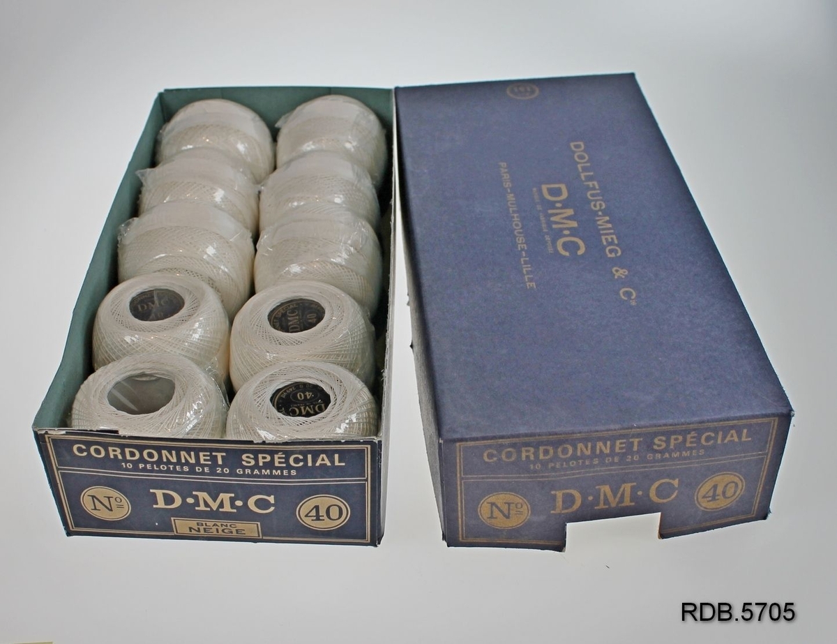En blå pappeske som inneholder 10 nøster DMC bleket hvitt bomullsbrodergarn nr 40.