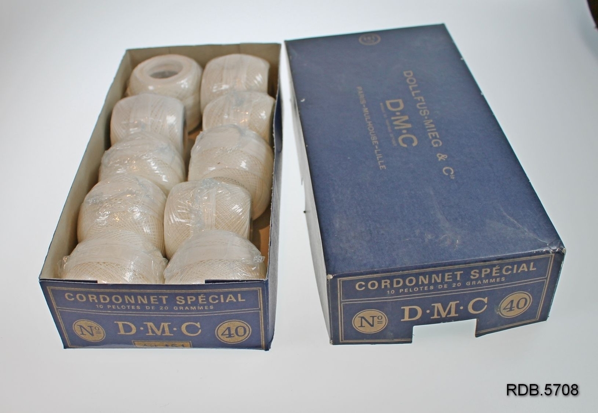 En blå pappeske som inneholder 10 nøster DMC bleket hvitt bomullsbrodergarn nr. 40.