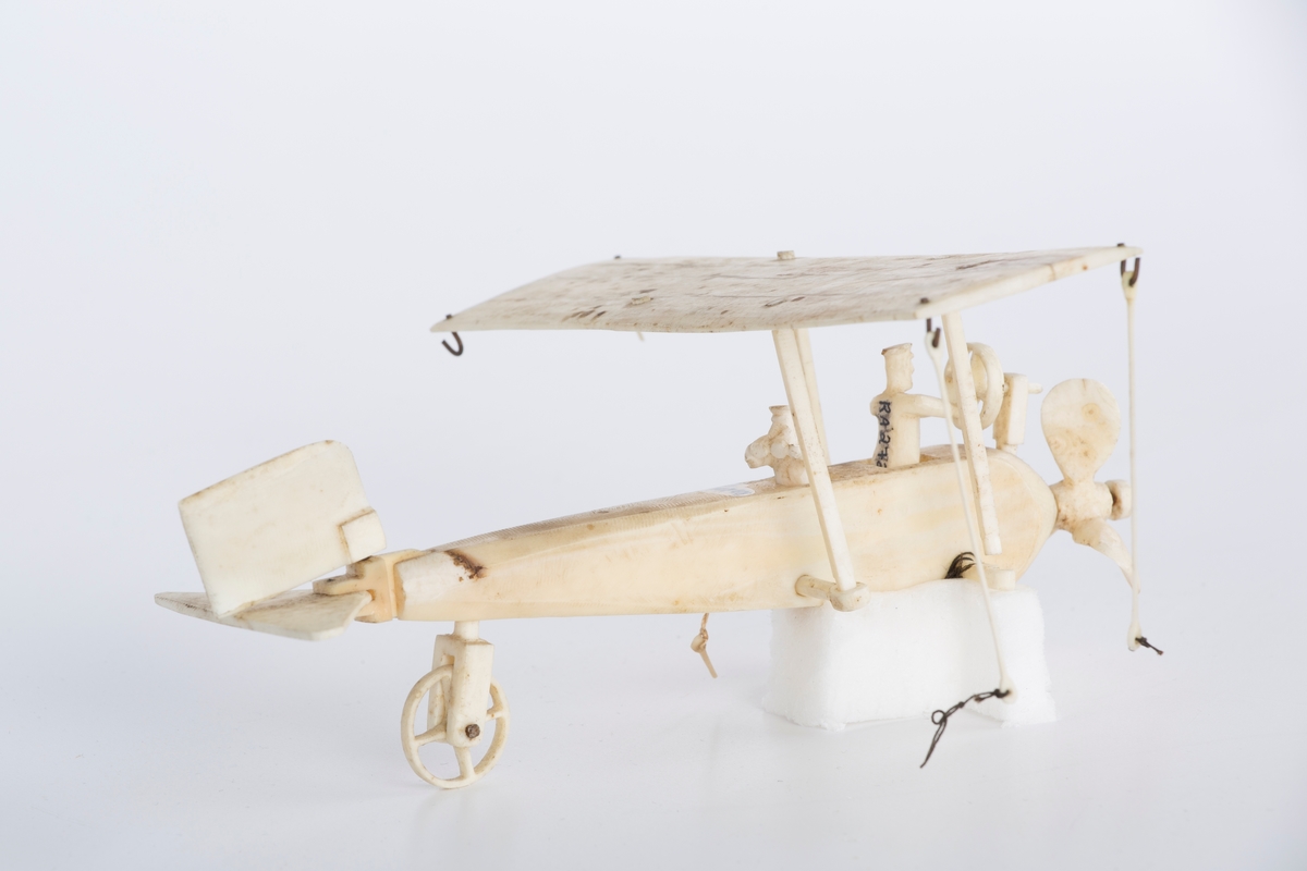 Modellfly i hvit ben. A)flykroppen B) vingen med en brukket stag C)Mann