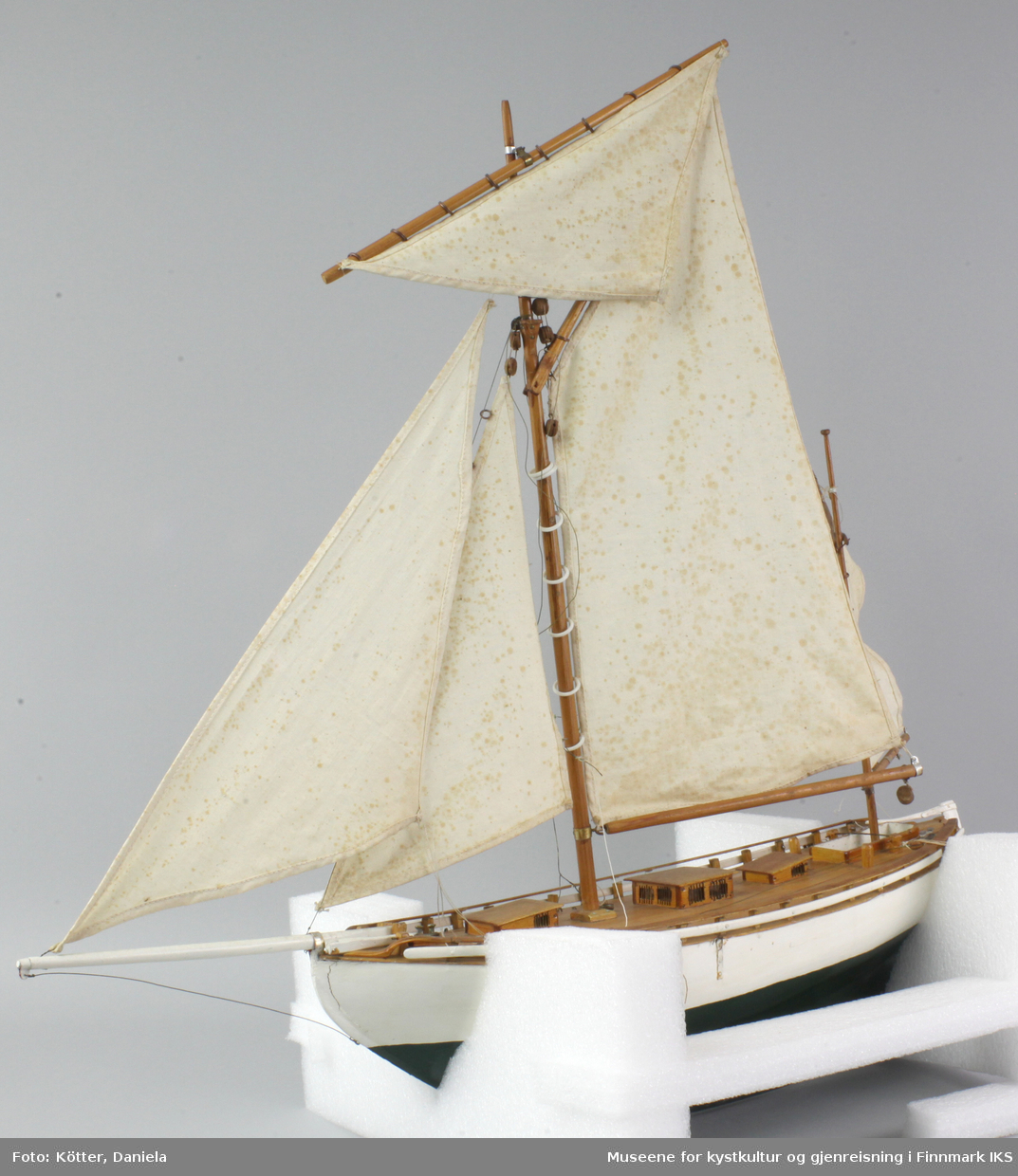 Modellbåten er hvit med grønn kjøl. Seilskøyten er spiss i begge endene og er gaffelrigget med fem seil. Den er en del løse deler.
