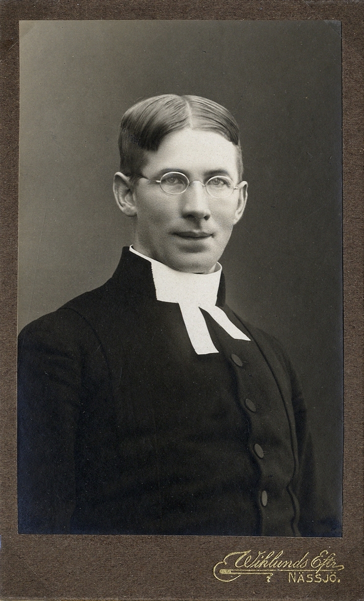 Porträttfoto av en man i prästdräkt m.m. 
Halvprofil, bröstbild. Ateljéfoto.