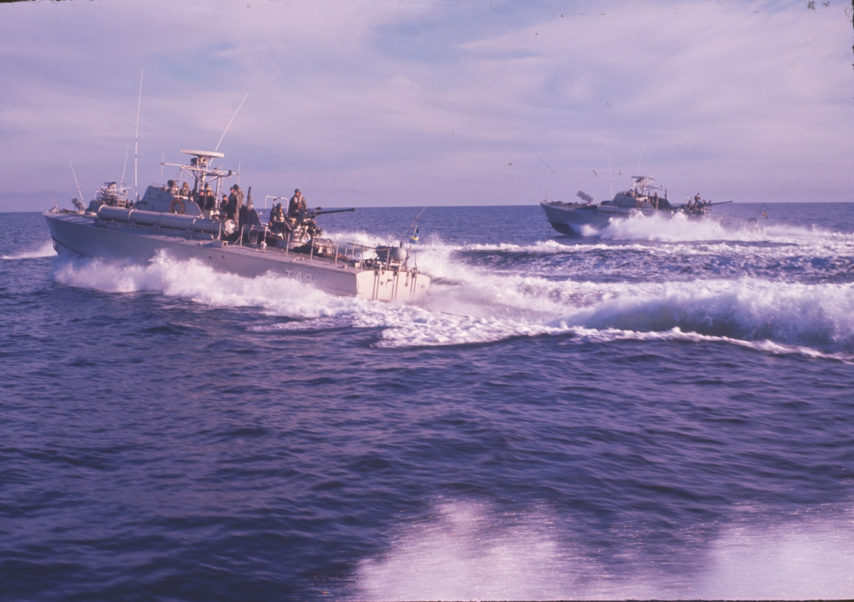 Bilden visar ett flertal motortorpedbåtar till sjöss som kör bredvid varandra i full fart.