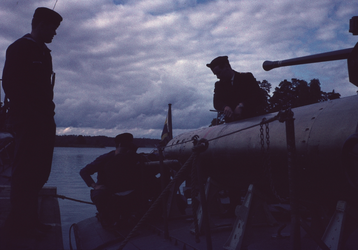 Bilden visar flera sjömän som arbetar vid en torpedtub ombord på en motortorpedbåt.