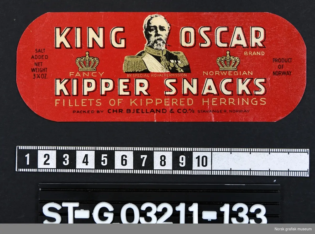 Rød etikett med detaljer i gull og sort. På midten er et portrett av Oscar II og to kroner er fremstilit på hver side. 

"Fancy Norwegian kipper snacks fillets of kippered herrings"