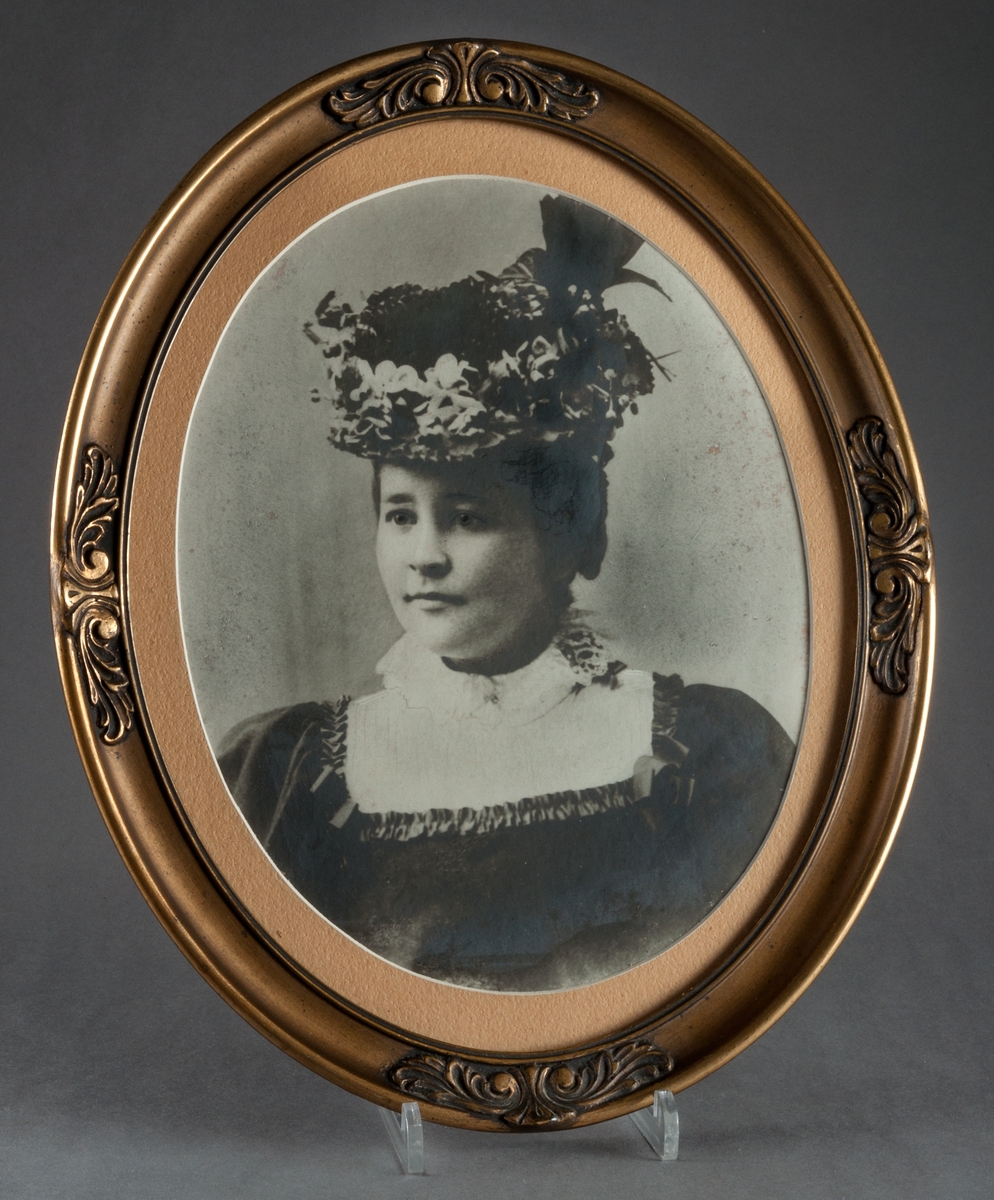 Fotografi i oval ram föreställande Anna Eleonora Elisabeth Qvist. Svartvitt foto på kvinna från tiden runt sekelskiftet 1900.