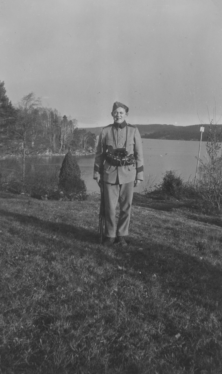 Porträtt av Gunnar Lundin, frivillig luftbevakare under beredskapstiden. I uniform, utomhus vid sjön Stora Le i Dalsland.