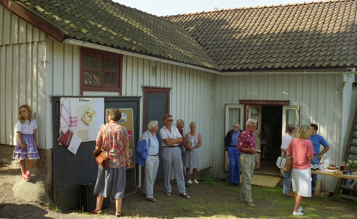 Invigning av Ekebackens Hantverksgård (tidigare John Lindströms möbelsnickeri) på Gamla Riksvägen 81, början av 1990-talet. Besökare står samlade utanför entrén.