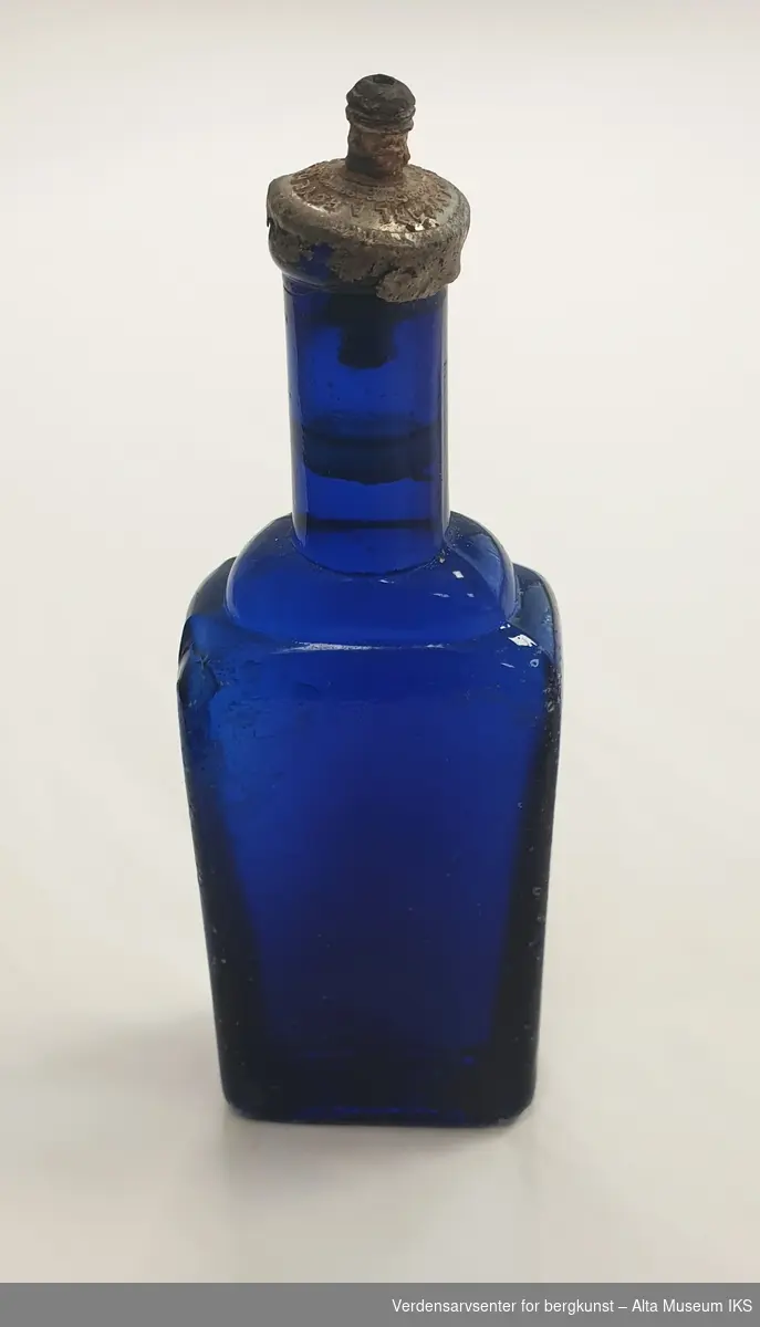 Munnvann på blå glassflaske med kork av metall.