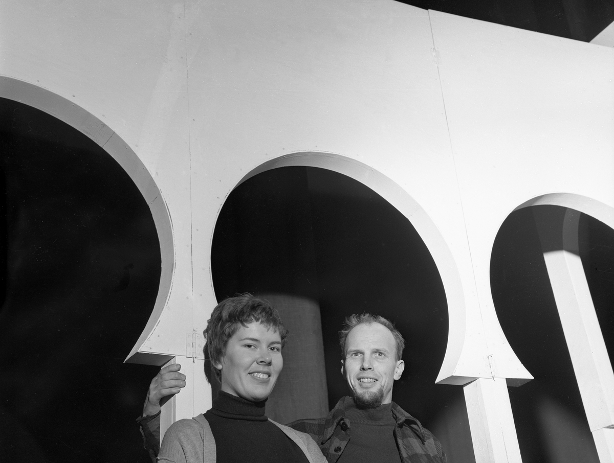 Kunstnerekteparet Inger Sitter og Carl Nesjar i buegangen til "Den nye verden" på Folketeatret. I Paris har de vunnet konkurransen om dekorasjonene til Lope de Vega's drama om Columbus "Den nye verden". Stykket skal settes opp på Folketeatret.